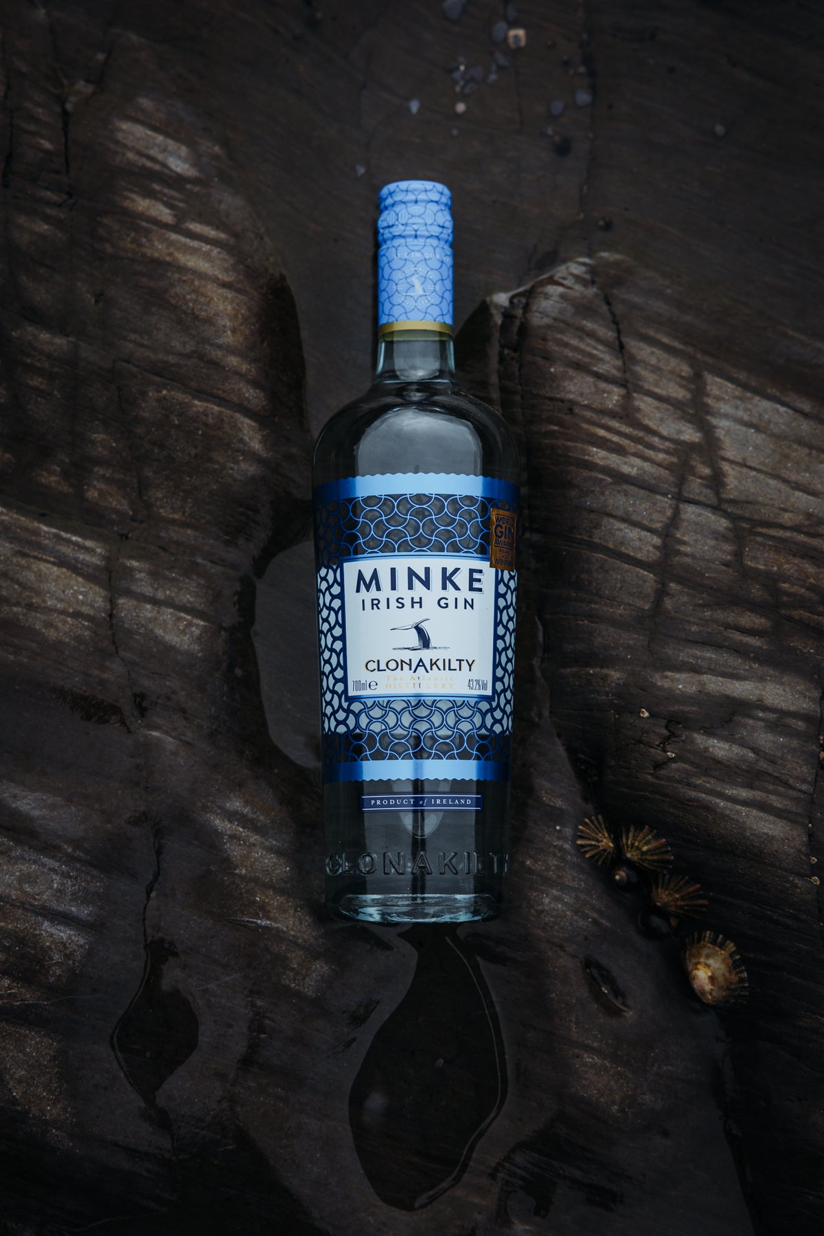 Minke Irish Gin bottle on dark coastal rock